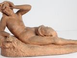 statue d'une femme allongée sur un rocher, sur un fond blanc