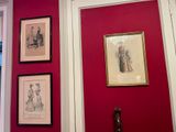 three framed pictures on the wall of a red room