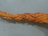 an image of a carving of a dragon on a wooden stick