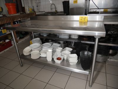 une table en acier inoxydable sur laquelle sont posés des saladiers et des casseroles