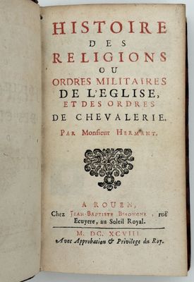 un livre ouvert posé sur une table blanche, dont la couverture porte un titre en noir et rouge