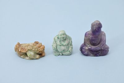 trois petites figurines de bouddhas assis les uns à côté des autres