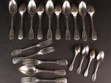 un grand nombre de cuillères et de fourchettes disposées sur une table