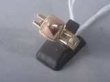 une bague en or ornée d'un cœur, posée sur un morceau de cuir noir