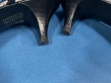 a pair of black high heeled shoes on a blue background