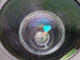 a close up of a camera lens with a blue object in it