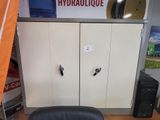 a black office chair sitting in front of a white cabinet