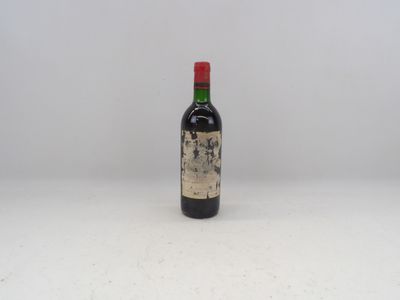 une vieille bouteille de vin posée sur une table blanche