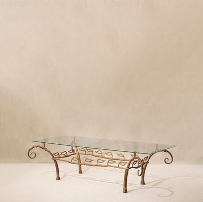 table basse en fer forgé avec plateau en verre et motifs en volutes