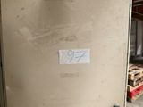 une affiche collée sur la porte d'un réfrigérateur dans un garage