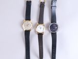 trois montres différentes sont alignées sur une surface blanche
