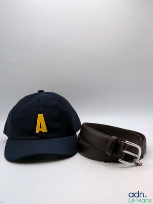 deux chapeaux et une ceinture sont posés sur une surface blanche