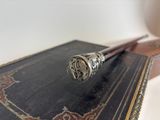 a silver pipe sitting on top of an old book