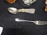 a fork, spoon, and glass on the table