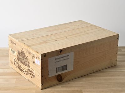 une boîte en bois portant une étiquette, posée sur un plancher en bois