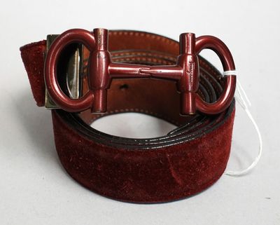 une ceinture rouge avec une boucle métallique sur un fond blanc