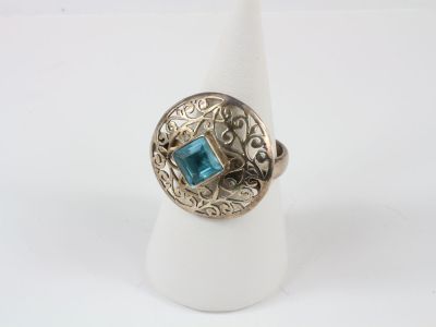 a close up of a ring with a blue stone in it