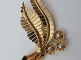 an image of a gold brooch with a bird on it