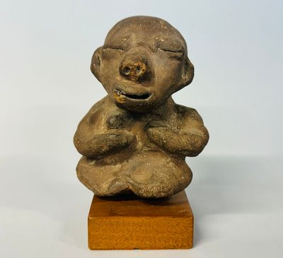 statue représentant un bébé assis sur un bloc de bois