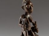 an image of a bronze statue of a woman with an axe