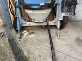 une bétonnière garée dans un garage, à côté d'une grille métallique