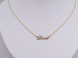 a gold necklace with the word love written on it