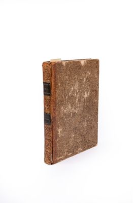 an old book that is sitting on a white surface