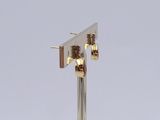 pair of gold plated earrings on a silver metal stand