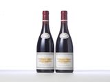 two bottles of red wine sitting on top of a table