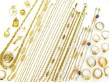 a lot of gold jewelry on a white surface