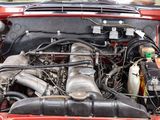a red car with its hood open and the engine in the trunk