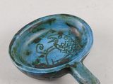 un petit bol bleu orné d'un motif de poisson