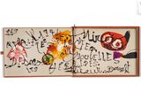 an open book with a drawing on it with writing on it