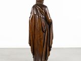 a wooden statue of a man in a robe and hat