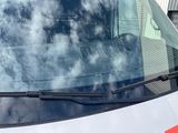 a white van parked in front of a building with clouds in the window