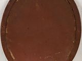an image of a brown round metal object on a white wall