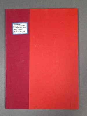 un livre rouge posé sur une table, à côté d'un autre livre rouge