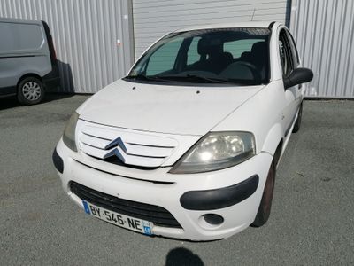 a small white car parked in front of a building