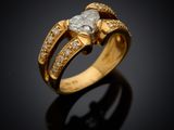 a close up of a gold ring with a heart shaped diamond