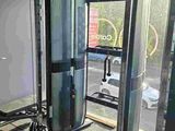 a gym room with two machines and a bench in it