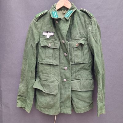 an image of a green military jacket hanging on a hanger