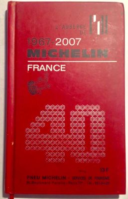 a red book sitting on top of a table next to a white wall