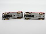 two silver and red toy trains sitting side by side on a white surface