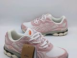 a pair of pink and white running shoes with a tag on them