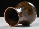 a brown vase that is sitting on a table