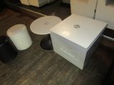 a white box sitting on the floor next to two black stools