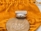 an image of a gold bag with a ring on top of it