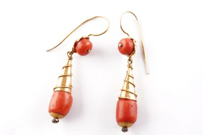 une paire de boucles d'oreilles en corail rouge et en or sur fond blanc