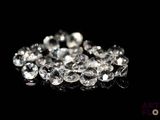 des diamants sur une surface noire avec un fond noir