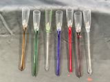 four different colored plastic spoons sitting next to each other on top of a table